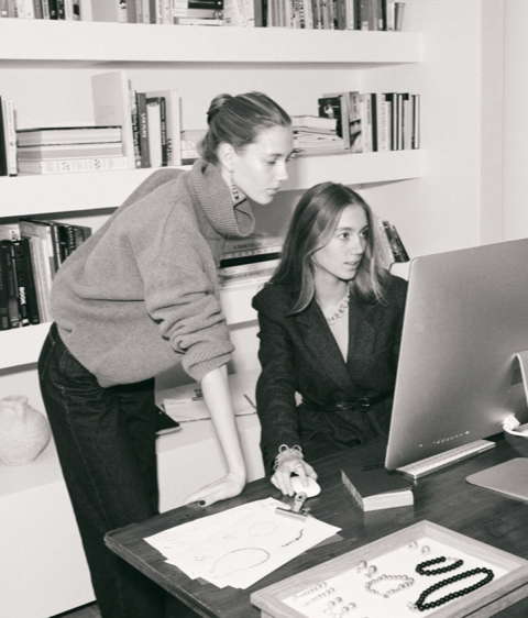 Two women looking at a computer pondering the importance of brand authenticity