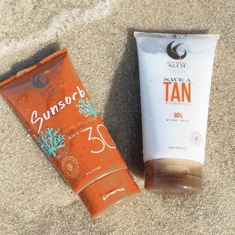 Key West Aloe Save A Tan and sunscreen products on sand