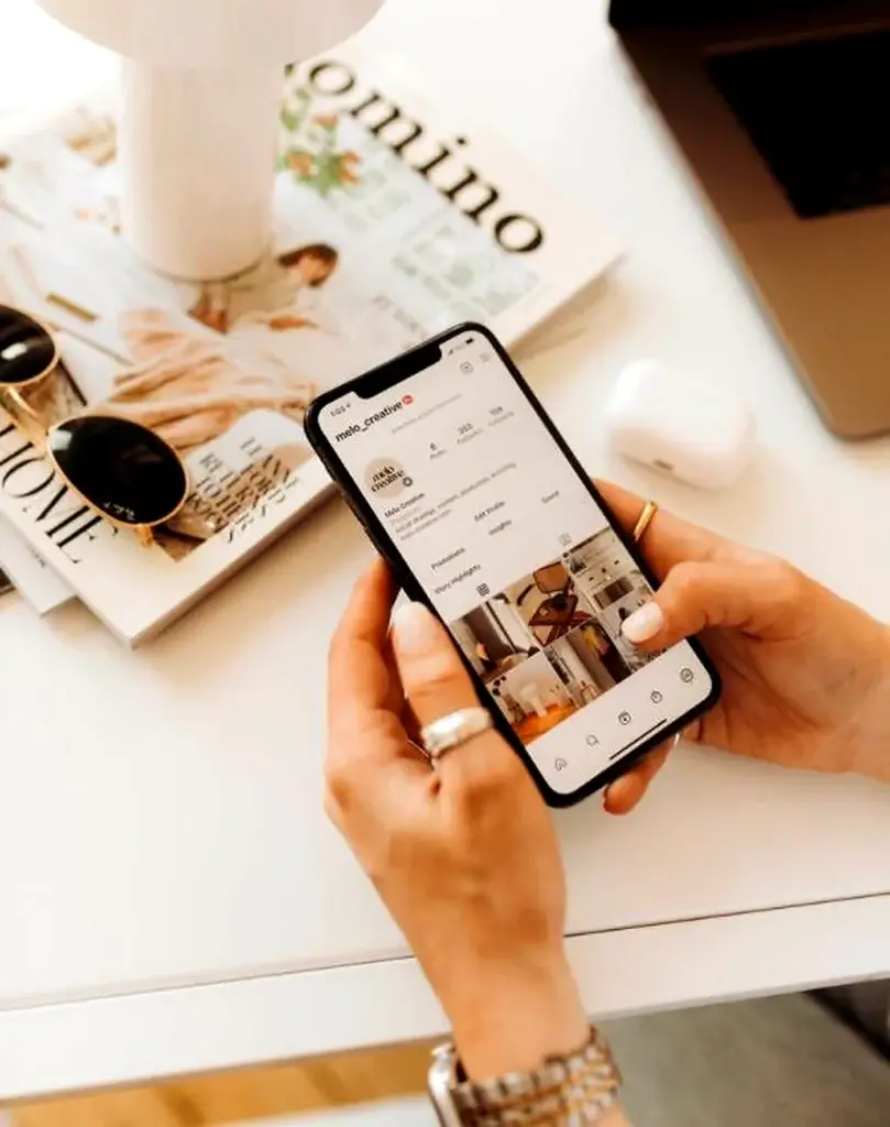 Woman browsing a beauty Instagram profile on her phone