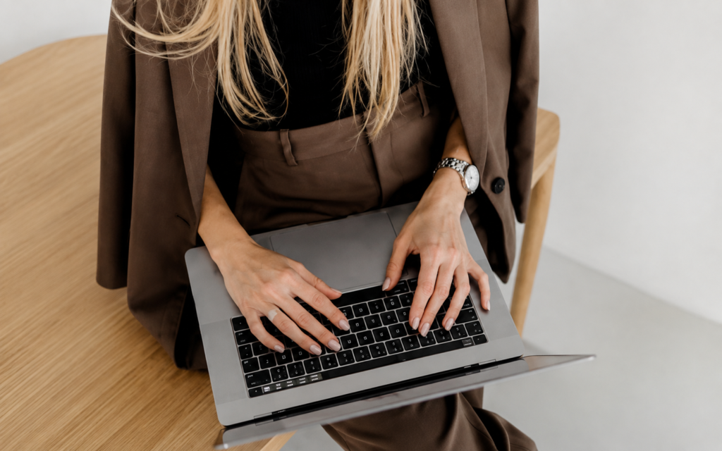 Marketing professional using a laptop to research brand visibility and AI discoverability across digital platforms.